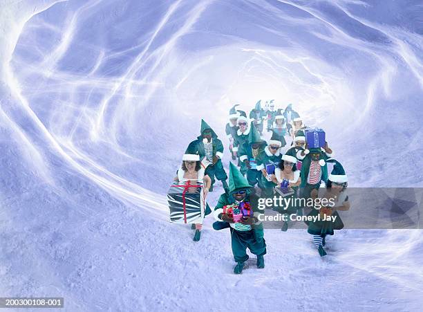 christmas elves walking through snow tunnel carrying presents - pixie stock pictures, royalty-free photos & images