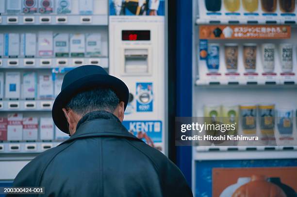 man standing in front of shop, rear view - paquete de cigarrillos fotografías e imágenes de stock