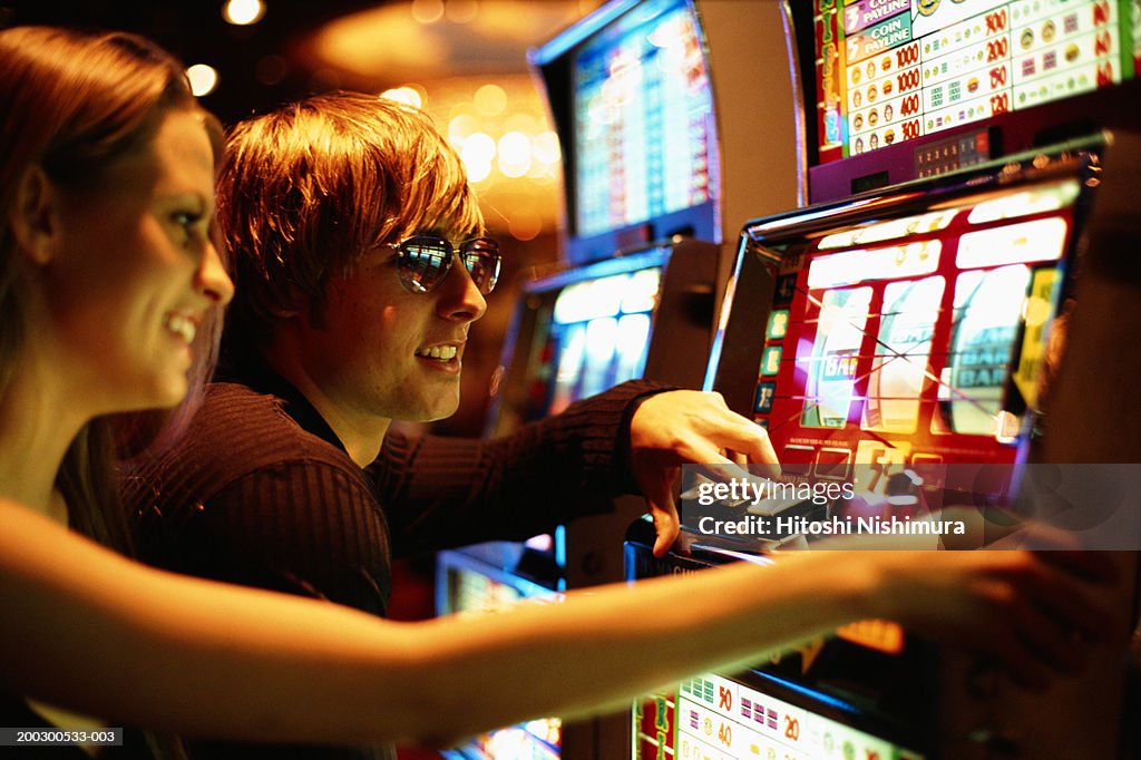 Young couple playing slot machine