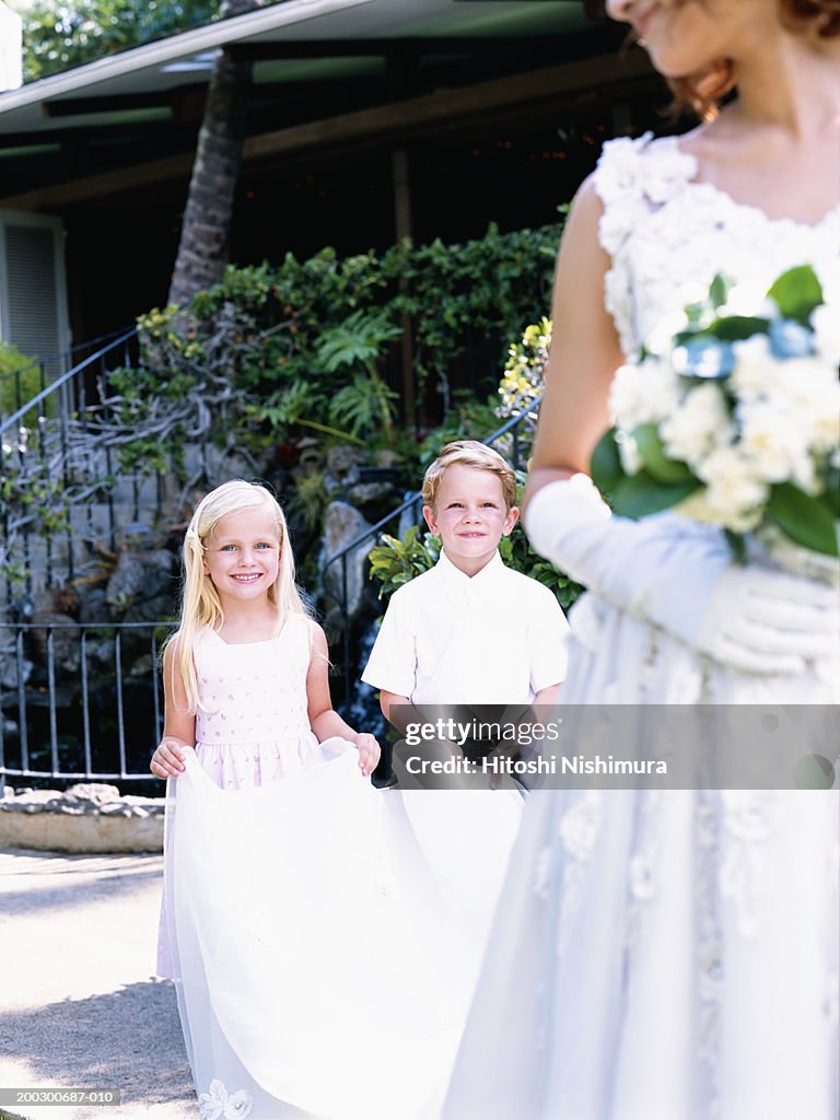Bridesmaid holding bride's veil