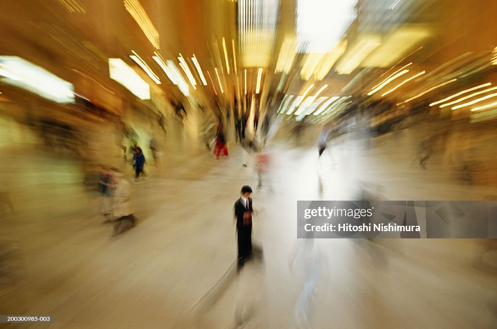 Businessman reading newspaper, elevated view, blurred motion