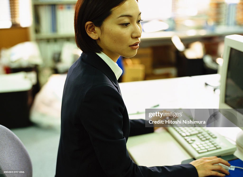 Businesswoman using computer, side view