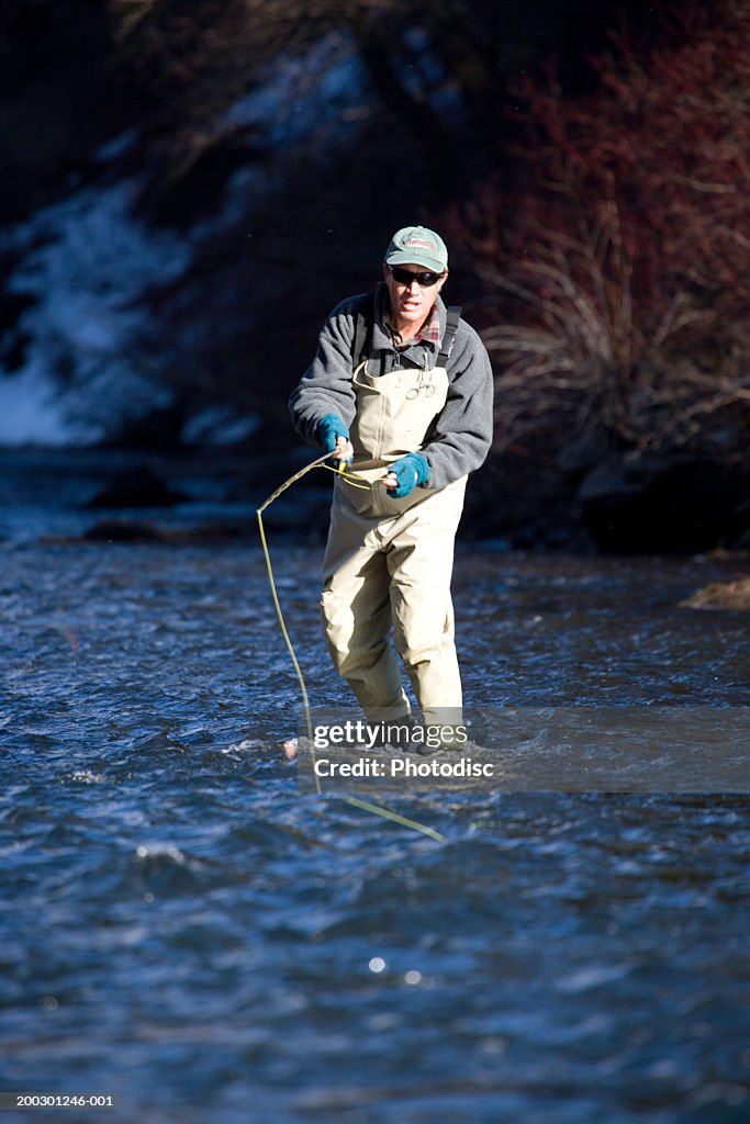 Man fishing in river, in winter