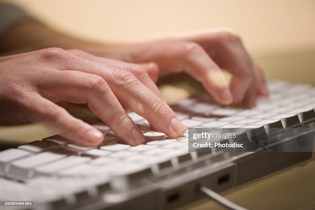 Man typing on keyboard, close-up of fingers
