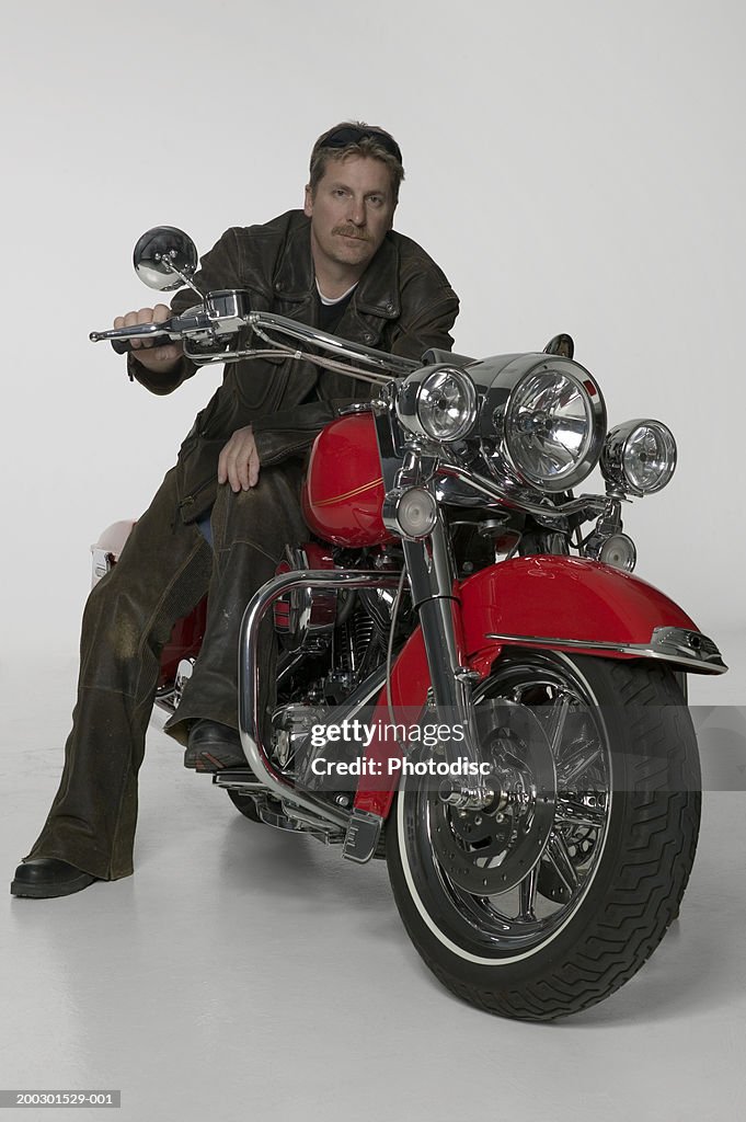 Man sitting on large red motorcycle, portrait
