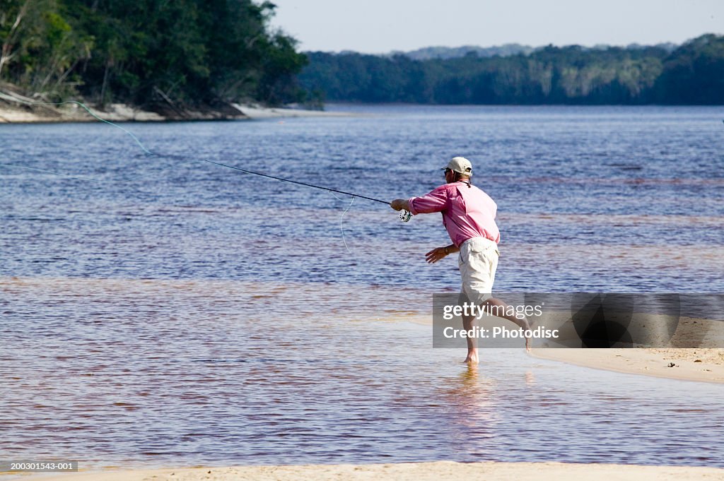 Man In River Casting Fishing Rod High-Res Stock Photo - Getty Images