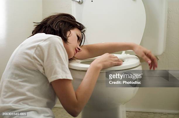 sick young woman leaning on toilet bowl - vomiting stock pictures, royalty-free photos & images