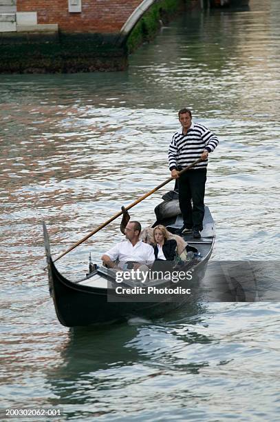 couple in gondola in canal in venice, elevated view - gondel stock-fotos und bilder