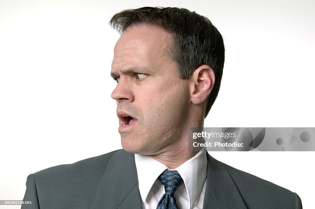 Man in suit looking shocked, in studio
