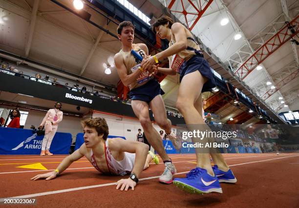 The team from Lexington-MA exchange the baton while an athlete from Upper Dublin-PA falls in the Boys' 4x800 race during the 116th Millrose Games at...