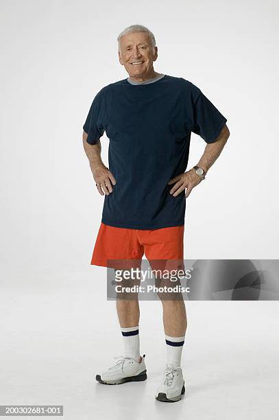 senior man with hands on hips, posing in studio, portrait - gray shorts stock pictures, royalty-free photos & images