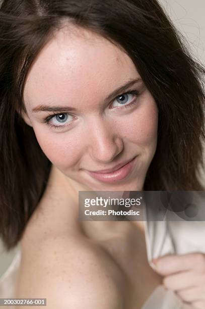 young woman with dark hair, exposing shoulder, posing in studio, portrait - female flasher stock pictures, royalty-free photos & images