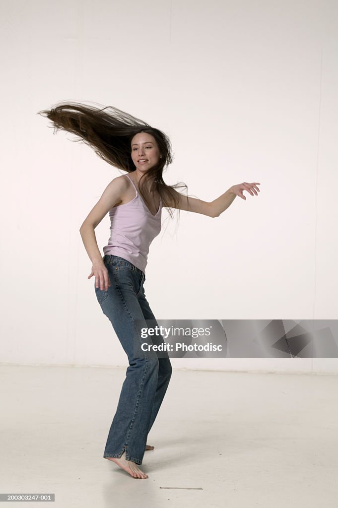 Woman dancing in studio, hair flying