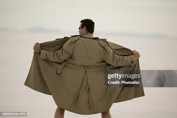 exhibitionist spreading front of coat, at beach - flasher fotografías e imágenes de stock