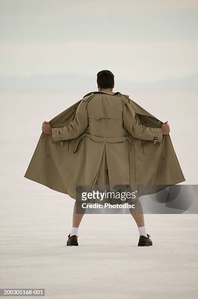 exhibitionist spreading front of coat, at beach - flasher fotografías e imágenes de stock