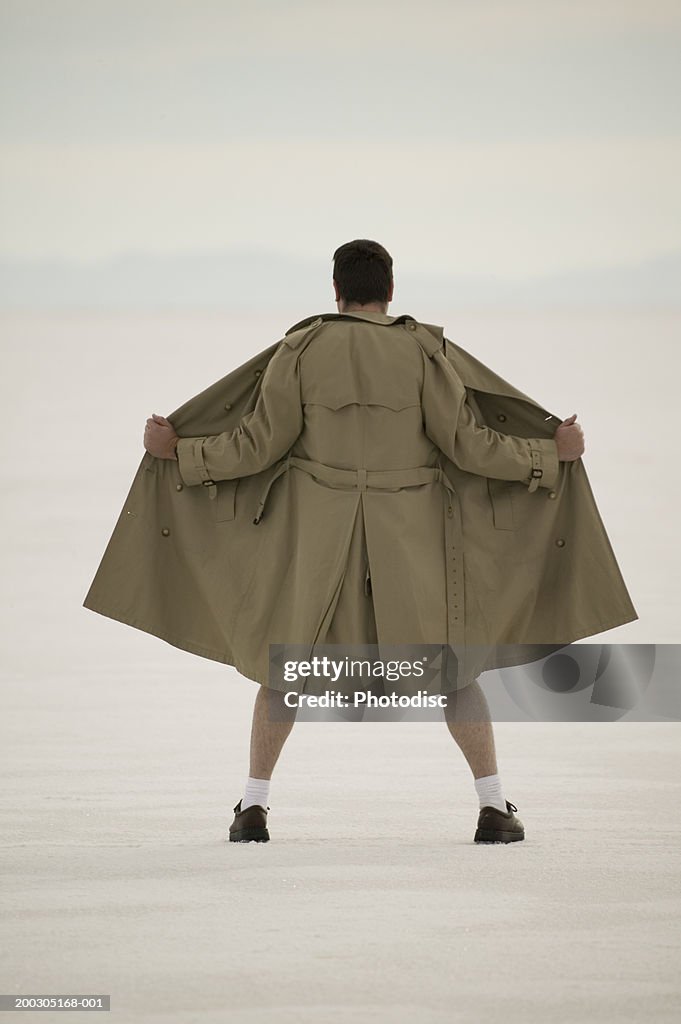 Exhibitionist spreading front of coat, at beach