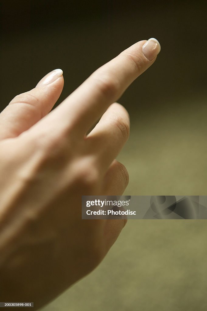 Woman pointing finger, close-up of hand