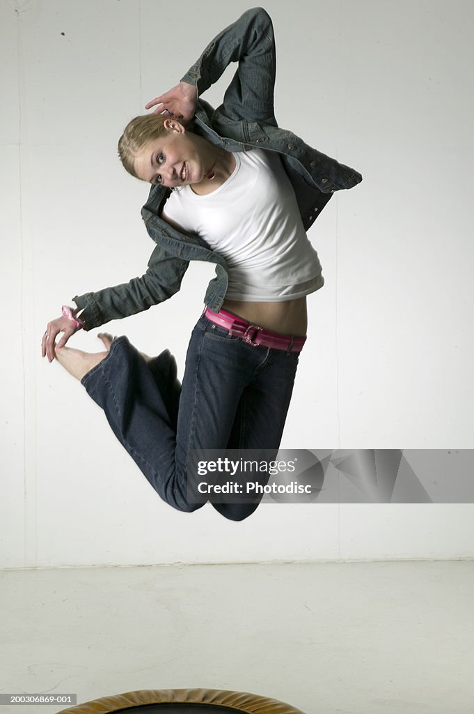 Woman jumping on trampoline in studio