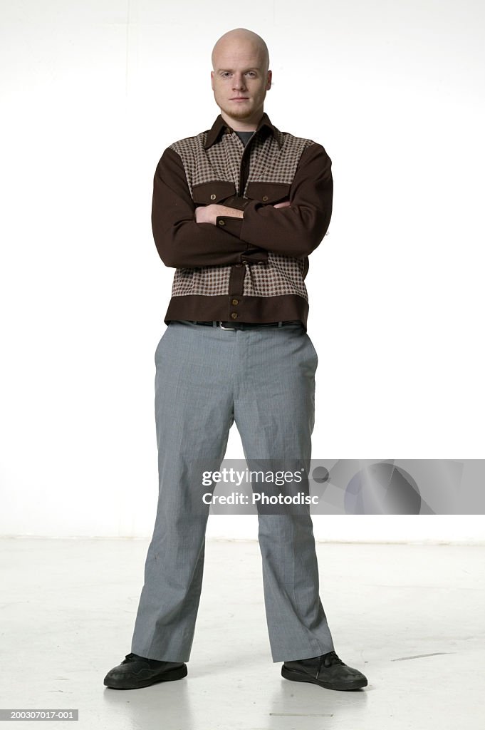 Man with arms folded, posing in studio, portrait