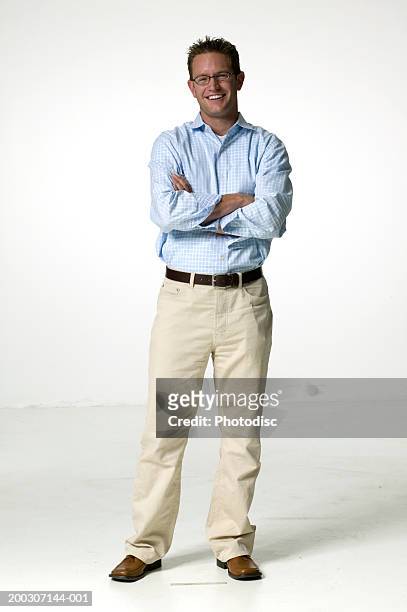 man wearing spectacles standing with arms crossed, posing in studio, portrait - pantalon beige photos et images de collection