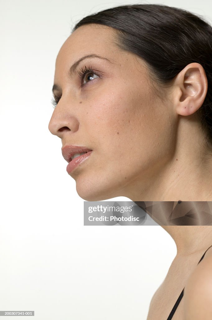 Young pensive woman with black hair, posing in studio, portrait