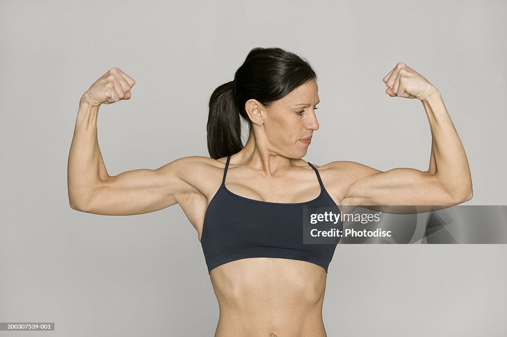 Woman Flexing Biceps In Studio High-Res Stock Photo - Getty Images