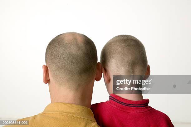 man and boy (12-13), standing rear in studio, close-up, high section - bald child stock pictures, royalty-free photos & images