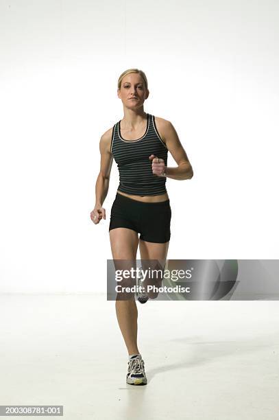 young woman in shorts and vest,  running, portrait - running shorts foto e immagini stock