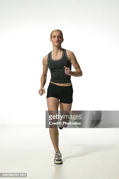 young woman in shorts and vest,  running, portrait - runner front view stock pictures, royalty-free photos & images