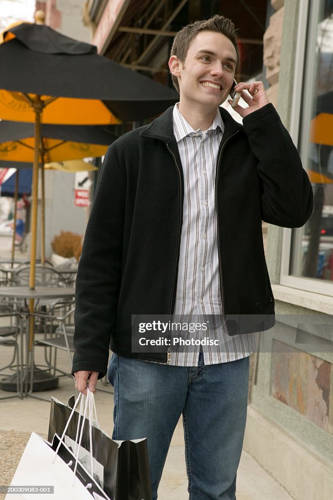 Young man talking on mobile phone in street