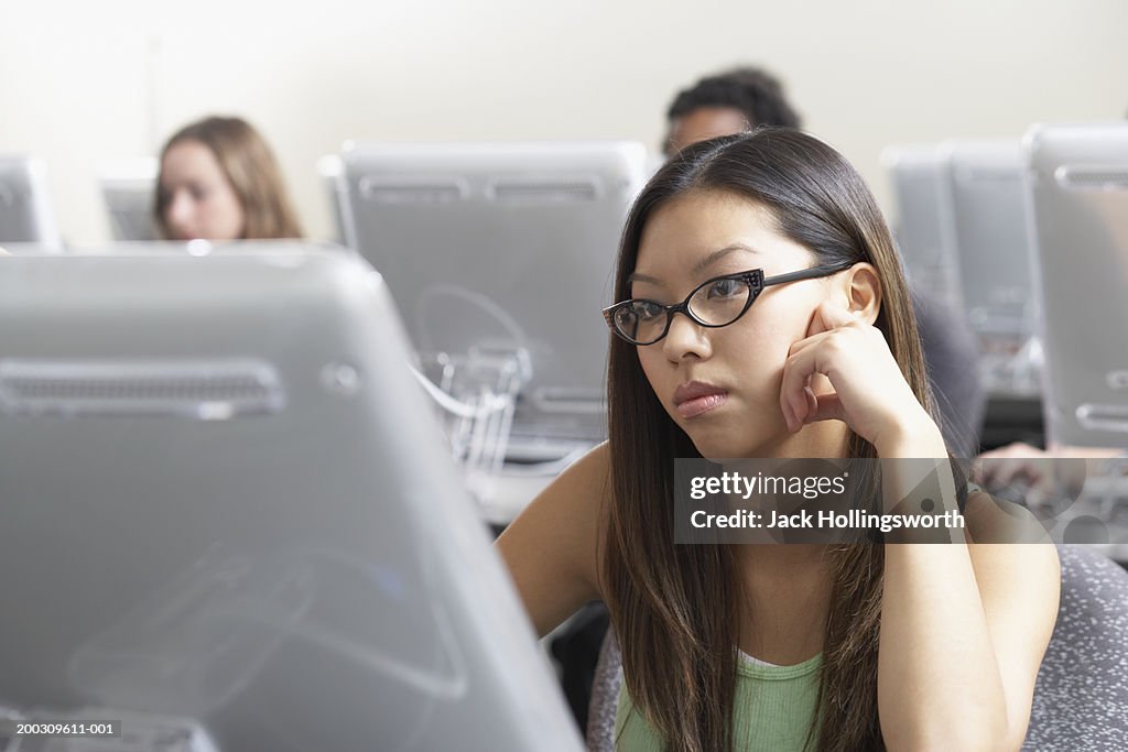 Young woman sitting in front of a computer monitor in a classroom