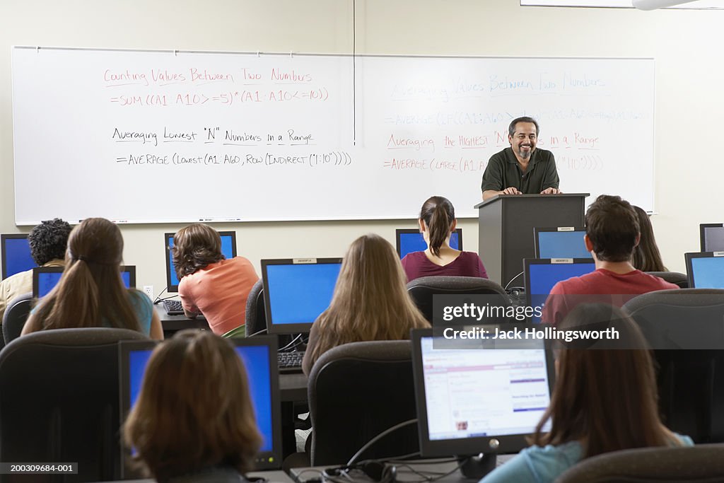 Rear view of a group of students sitting in front of computer monitors