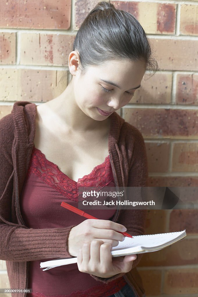 Young woman writing in a book