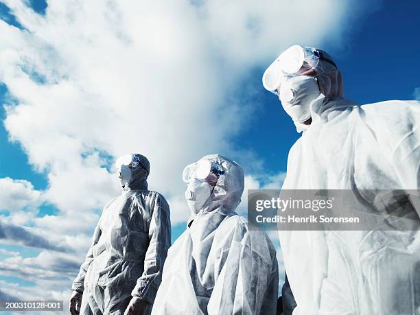 three men wearing protective suits, low angle view - renrumsdräkt bildbanksfoton och bilder