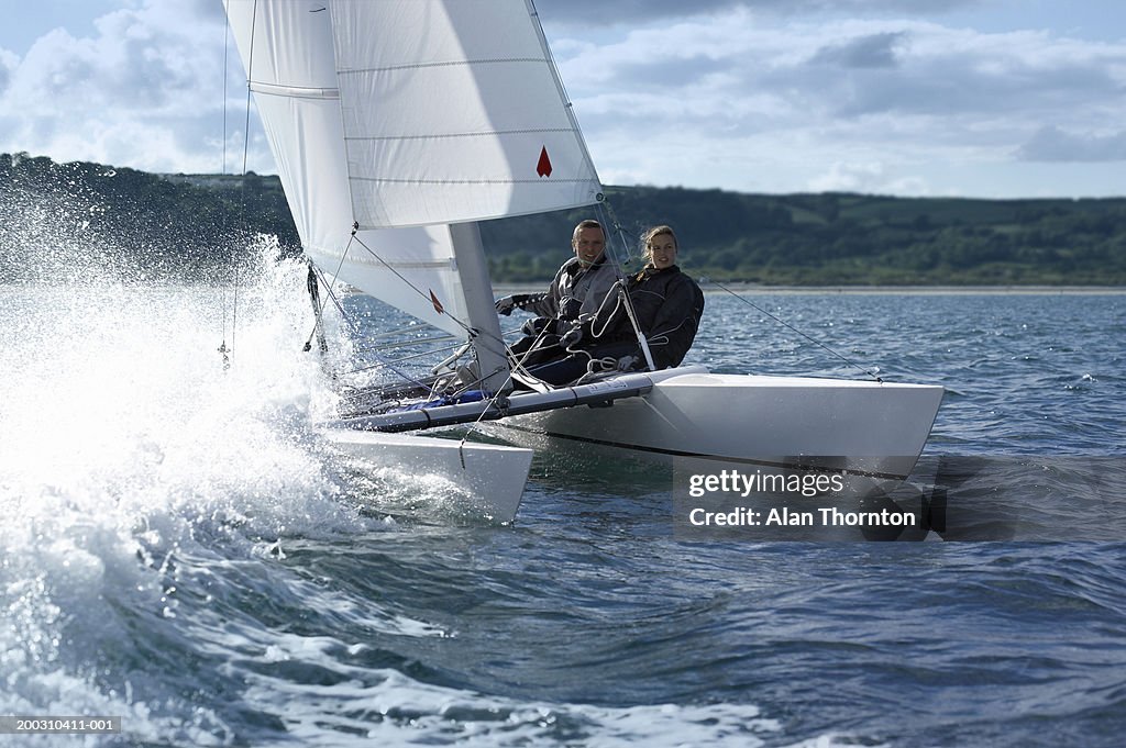 Couple sailing catamaran