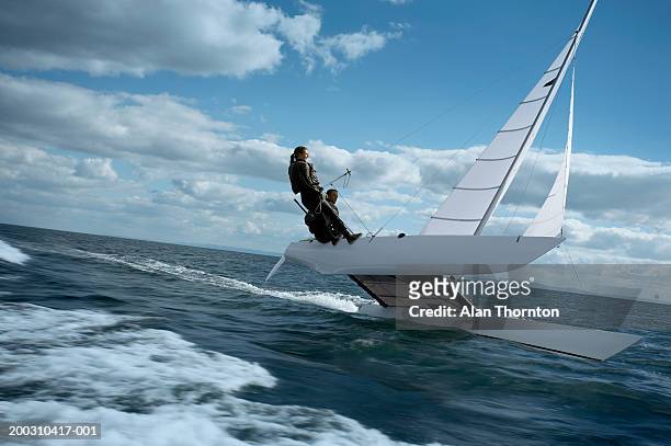 couple sailing catamaran - segeln stock-fotos und bilder