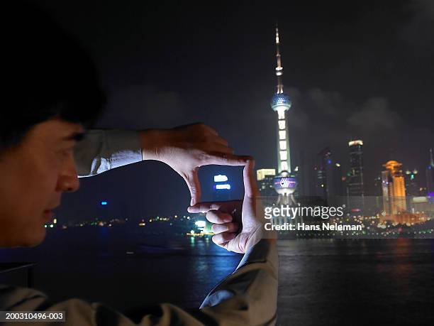 man framing part of skyline with fingers, night - dedos fazendo moldura - fotografias e filmes do acervo
