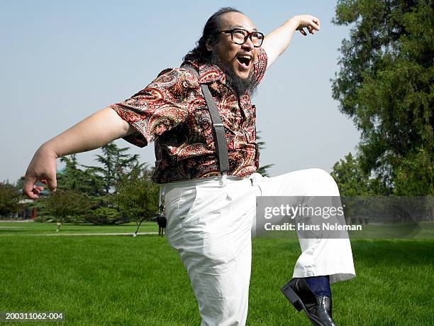 mature man doing martial arts exercise in park - paisley pattern stock pictures, royalty-free photos & images