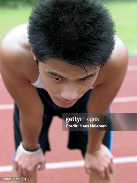 teenage male runner (17-19) resting after race - athlete defeat stock pictures, royalty-free photos & images