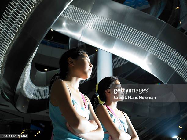 twin sisters (9-11) looking at exhibit in museum - girl museum stockfoto's en -beelden