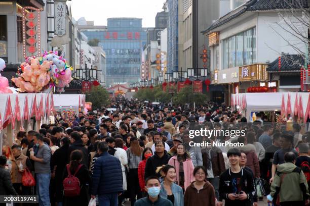 Tourists are visiting the crowded Guanqian commercial street in Suzhou, East China's Jiangsu province, on February 14, 2024.