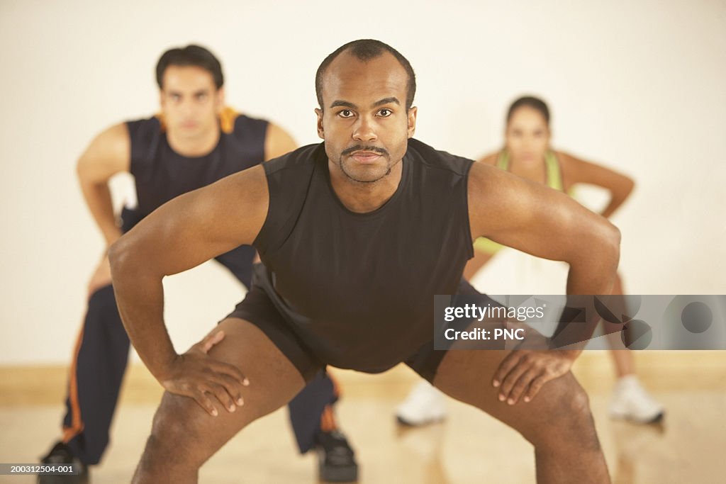 People stretching in exercise class (focus on man in foreground)