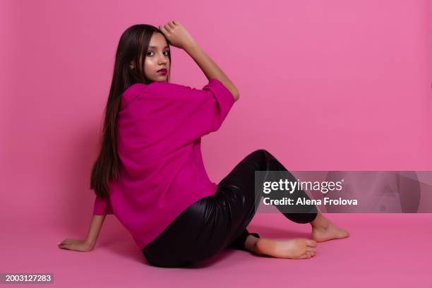 beautiful girl standing and smiling and dressing magenta jumper, leather trousers  pink background springtime - teen boots russian stock pictures, royalty-free photos & images