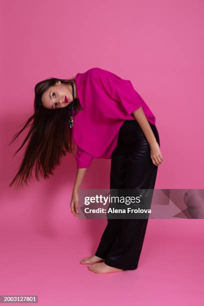 beautiful girl standing and smiling and dressing magenta jumper, leather trousers  pink background springtime - teen boots russian stock pictures, royalty-free photos & images