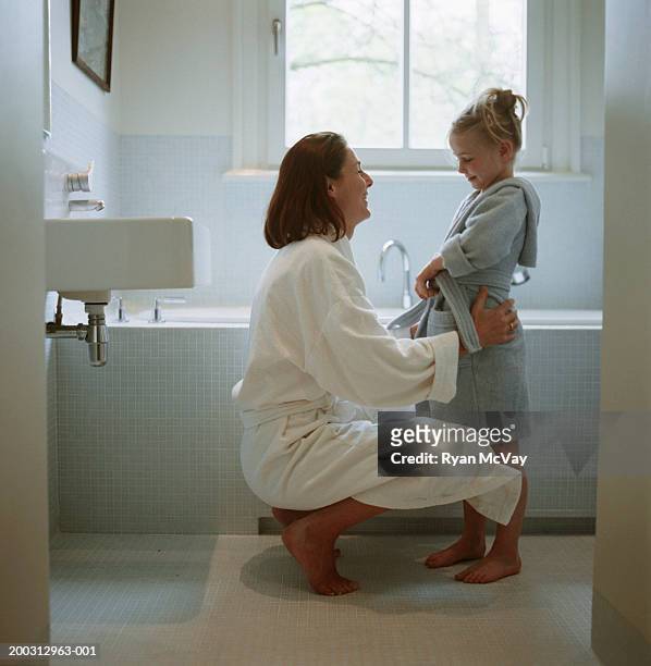mother and daughter (2-3) wearing dressing gowns in bathroom - kids dressing up stock-fotos und bilder