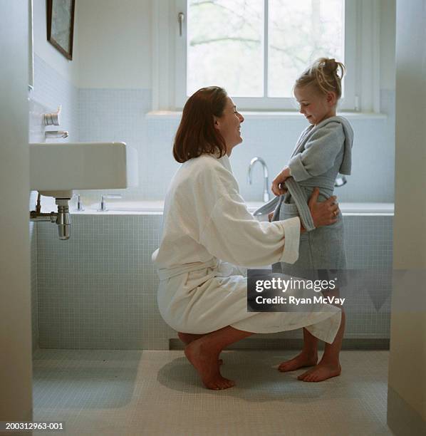 mother and daughter (2-3) wearing dressing gowns in bathroom - kid bath mother stockfoto's en -beelden