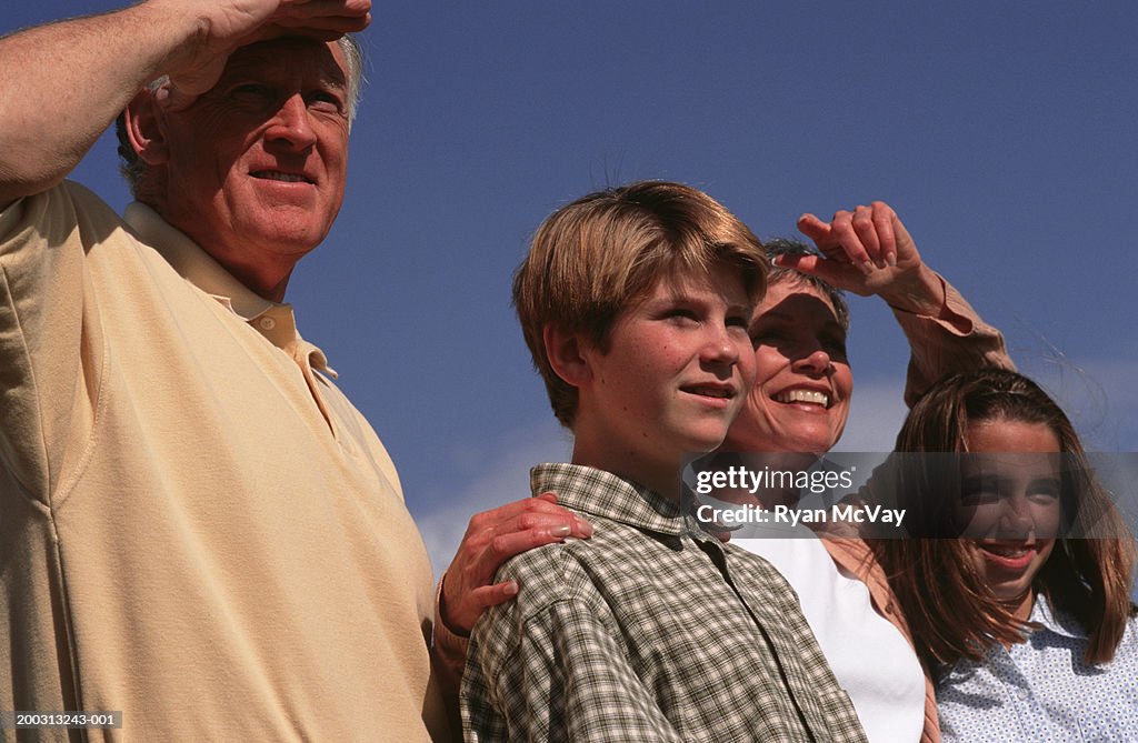 Grandchildren and grandparents standing near shore, (10-11), (12-13)