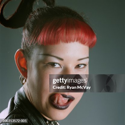 Young Woman Licking Lips Posing In Studio Portrait High-Res Stock Photo ...