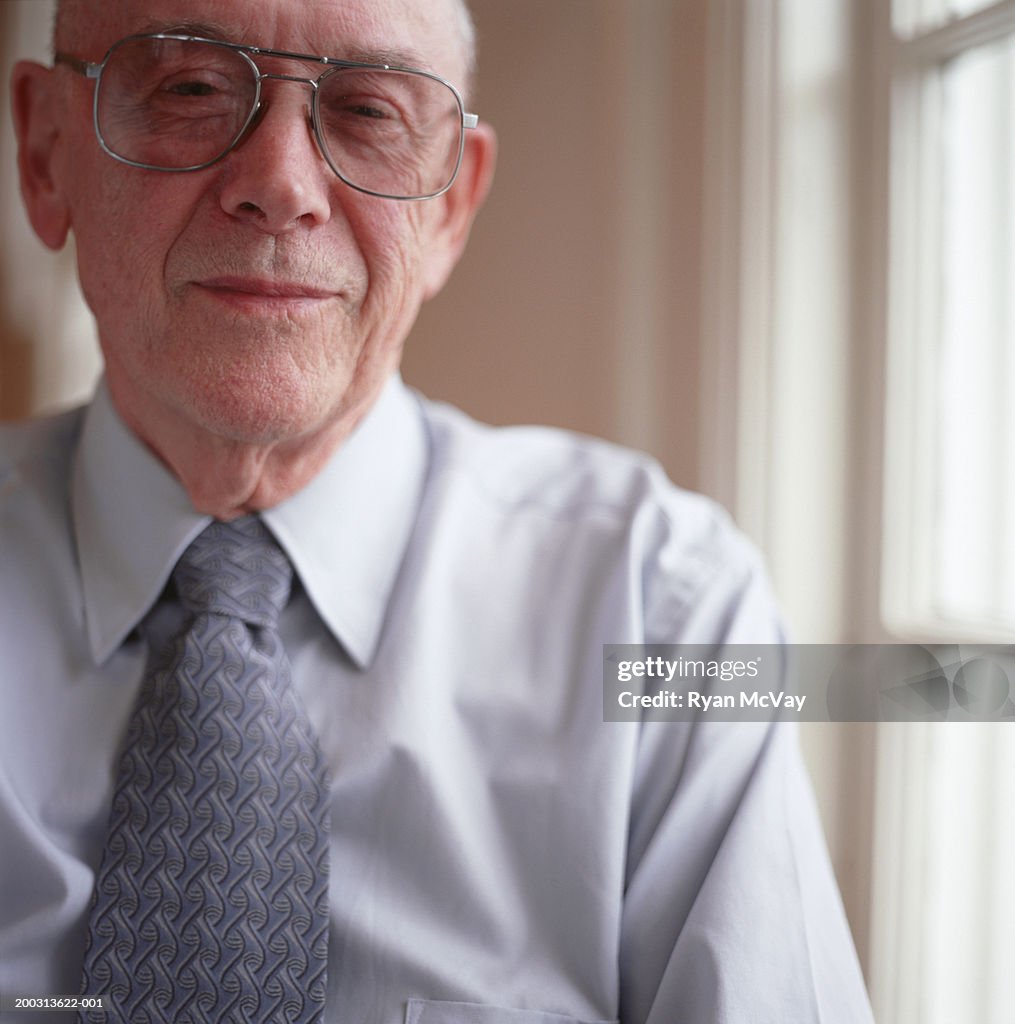 Senior man wearing shirt and tie and spectacles, posing indoors, close-up, portrait