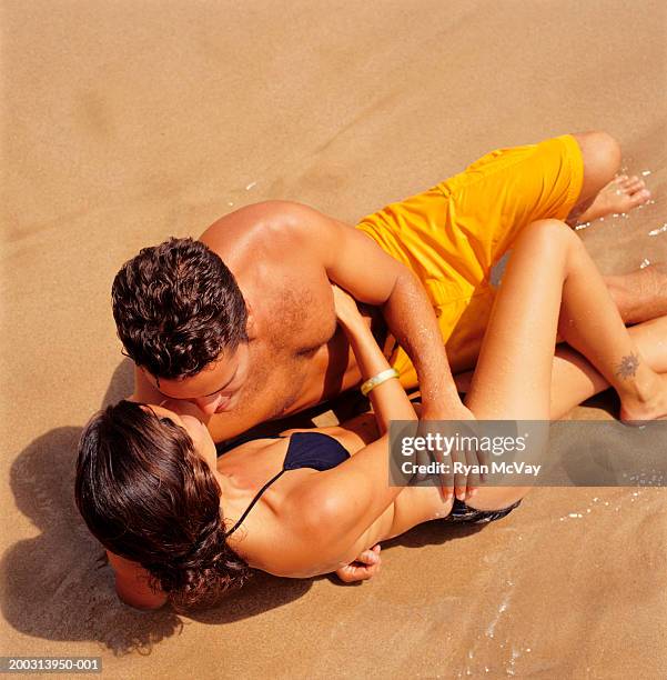 Couple Lying On Beach Embracing Elevated View, Foto de stock